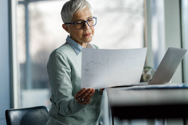 istock Mature businesswoman analyzing reports in the office. 1322632322
