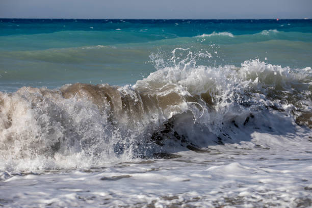 istock big waves with foam and sand near the shore, rest, horizontal