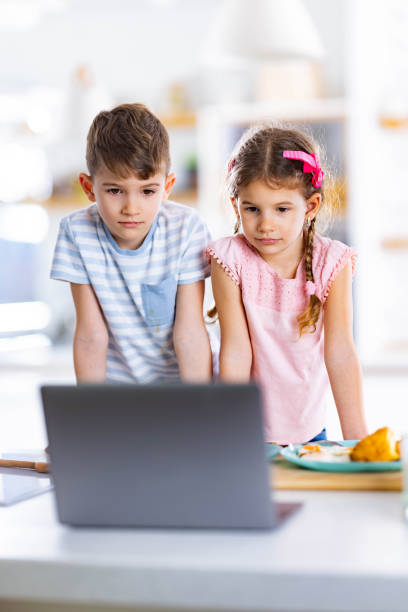 istock Small siblings watching something on laptop at home. 1322634124
