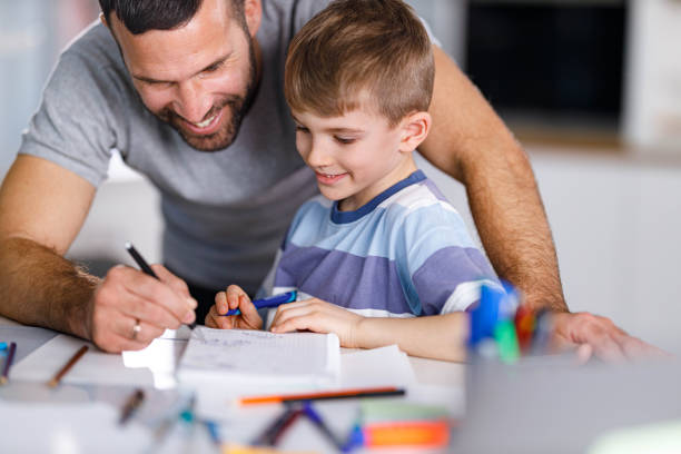 istock Happy single father helping his son with a homework. 1322635291