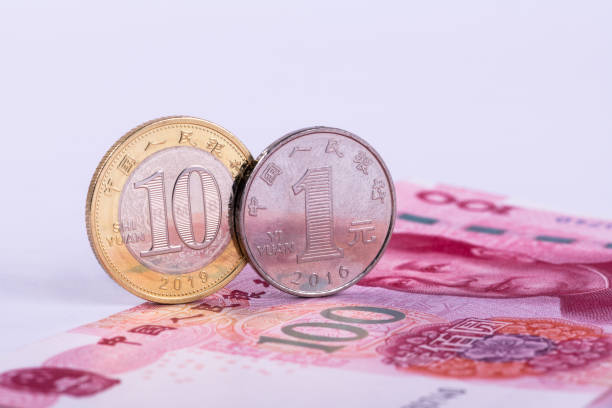 eine glänzende 10-yuan-münze und 1 yuan-münze stehen am rand einer 100-yuan-note - 10 yuan note stock-fotos und bilder