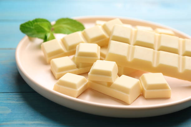 istock Delicious white chocolate and mint on light blue wooden table, closeup 1322640796