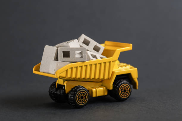 istock Toy dump truck delivering concrete block. Transportation construction materials on building site 1322640967