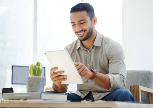 istock Shot of a young man using his tablet at work in a modern office 1322642237