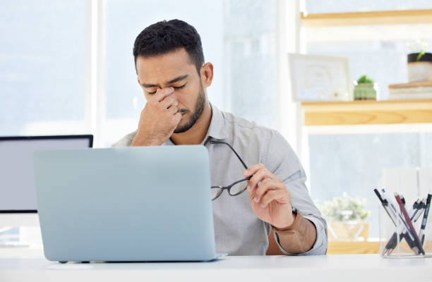 istock Shot of a young man having a headache at work in a modern office 1322642244