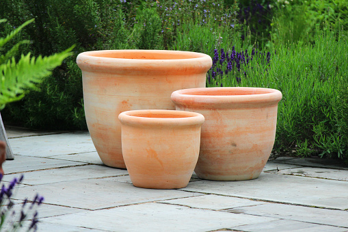 A trio of various sizes chalky clay pots.