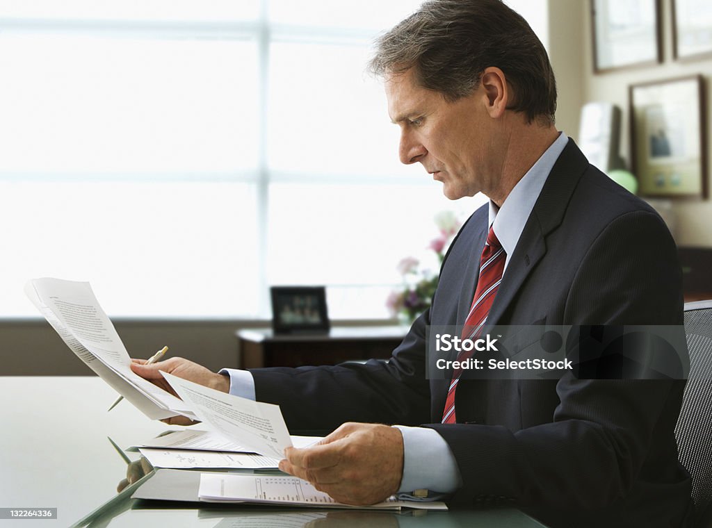Uomo d'affari andando su report - Foto stock royalty-free di 50-54 anni