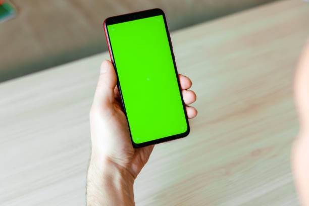 istock Mobile phone with green screen. Hold his man's. 1322643850