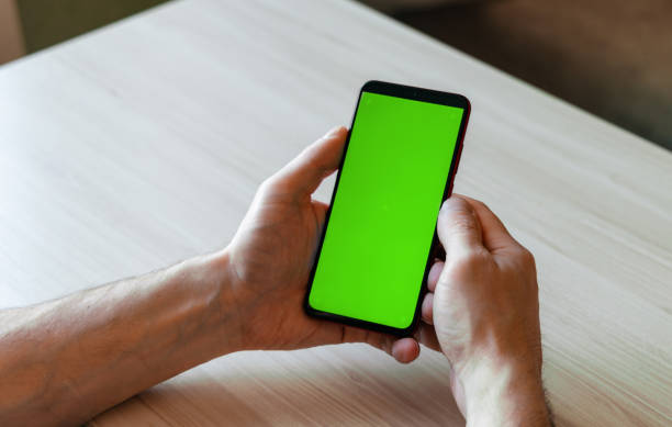 istock Mobile phone with green screen. Hold his man's. 1322644397