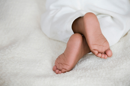 Close-up view of a baby feet holded by her mom. Copyspace