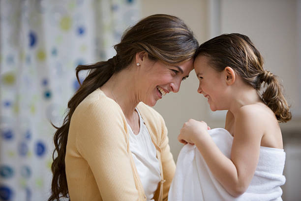 madre e hija touching foreheads después de baño - little girls women red bathroom fotografías e imágenes de stock