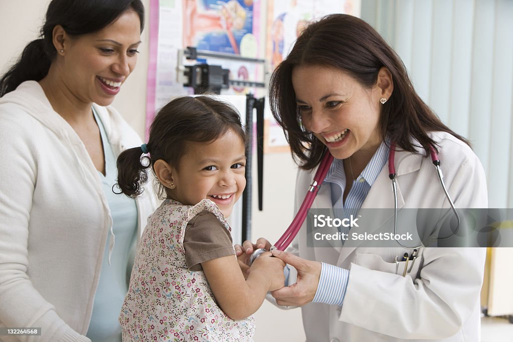 Toddler girl laughing while doctor examines West New York, NJ Doctor Stock Photo