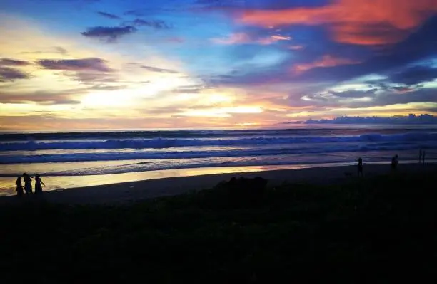 The beautiful view of the sunset on the beach of Bali, the gradation of the color of the clouds from blue to orange illustrates the beauty of the natural panorama of the coast of Bali.