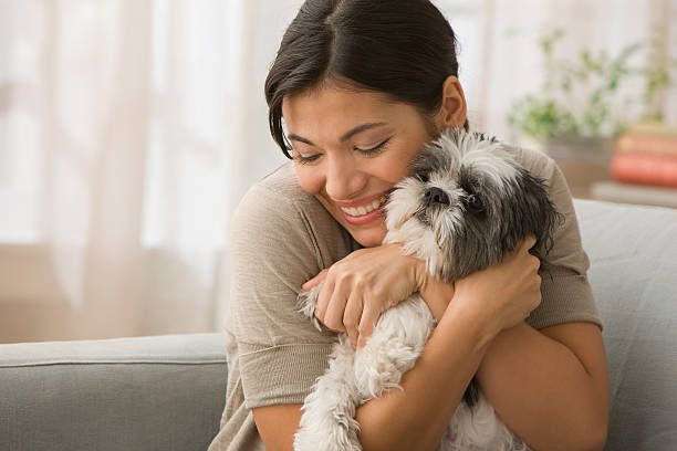 jeune femme embrassant chien - native habitat photos et images de collection