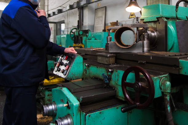 istock Heavy industrial worker performs a mechanical operation on a machine for the production of steel structures 1322646884