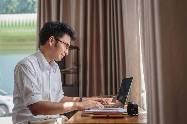istock Young Asian business man working with laptop computer while sitting at home 1322647086
