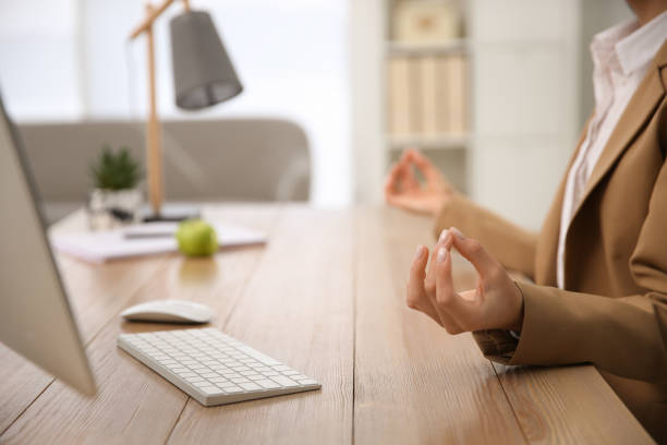 istock Woman meditating at workplace in office, closeup. Space for text 1322647302