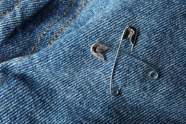istock Metal safety pins on denim fabric, closeup 1322648220