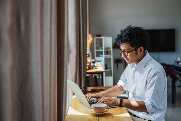 istock Young Asian business man working with laptop computer while sitting at home 1322651318
