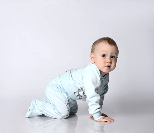 istock Sweet baby kid in bodysuite crawling, isolated studio 1322652139