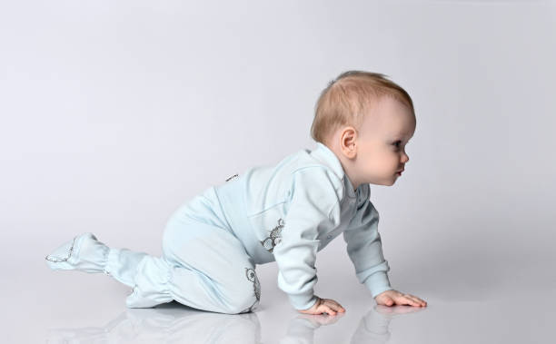 istock Sweet baby kid in bodysuite crawling, isolated studio 1322652148