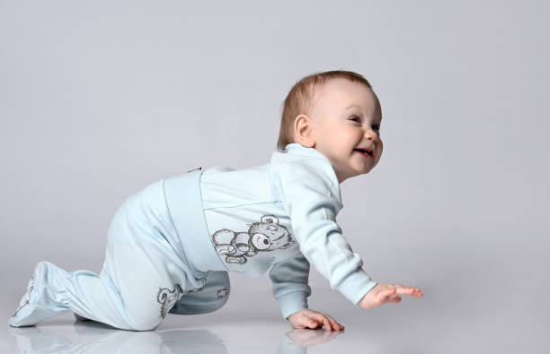 istock Creeping funny boy in body. He sits on the floor, isolated on a white studio background. Concept for articles about childhood or advertising for children. 1322652162