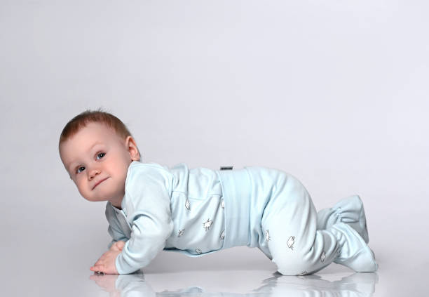 Creeping funny boy in body. He sits on the floor, isolated on a white studio background. Concept for articles about childhood or advertising for children.