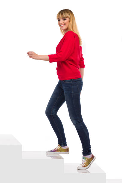 istock Smiling Young Woman Is Walking Up The Stairs 1322653621