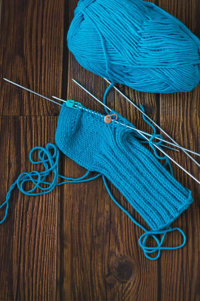 istock Knitting a warm sock from blue wool yarn 1322654342
