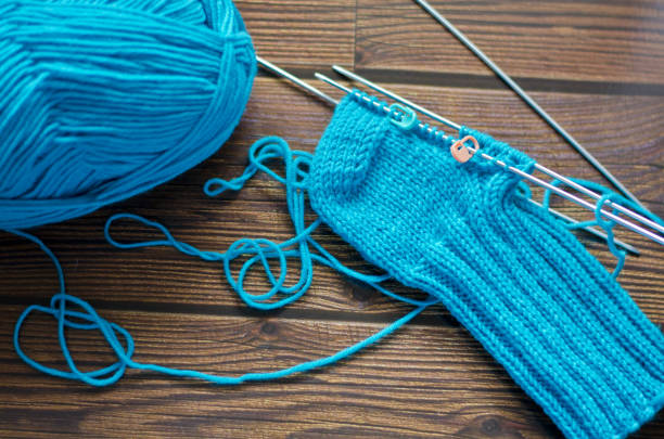 istock Knitting a warm sock from blue wool yarn 1322654846