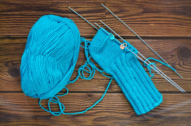 istock Knitting a warm sock from blue wool yarn 1322654898