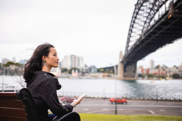 istock Asian Woman in 30's Sitting On The Bench Using Smartphone 1322655938