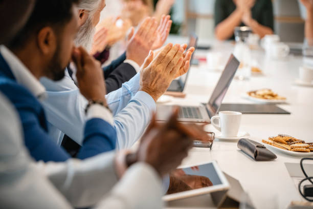 istock Businesspeople Applauding Presentation in Board Room 1322656537