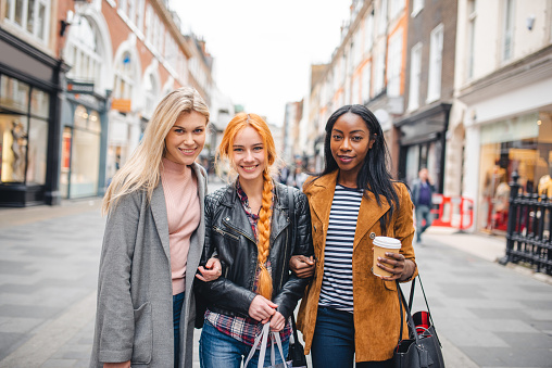 Retrato de tres mujeres jóvenes de compras en el centro de Londres photo