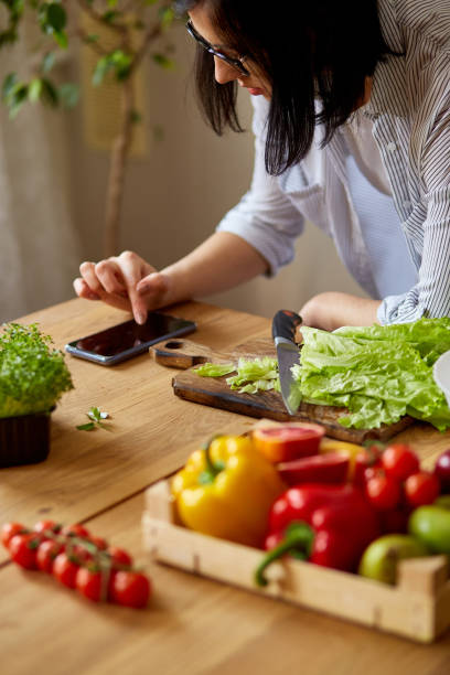 istock Woman is cooking in the kitchen at home, using digital tablet or smarthone 1322658016
