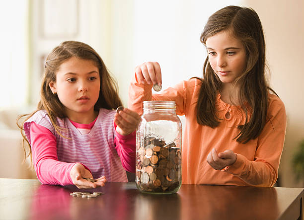 Two Sisters putting coins in a jar West New York, NJ counting coins stock pictures, royalty-free photos & images