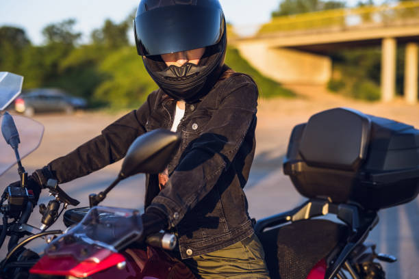 istock Female motorcyclist looking in the mirror 1322659493
