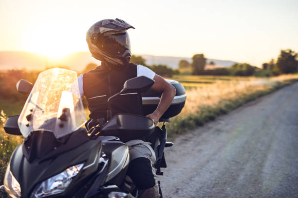 man on motorcycle enjoys in ride at sunset - motorcycle imagens e fotografias de stock