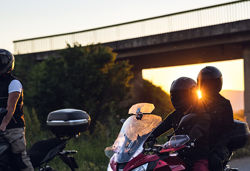 Motorcyclists rides bikes at sunset