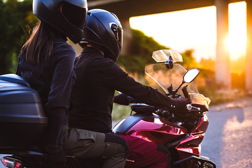 Couple enjoys in motorcycle ride at sunset