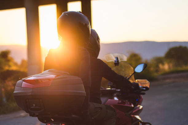 Couple enjoys in motorcycle ride at sunset