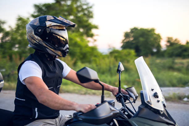 istock Mature man rides motorcycle on country road 1322659705