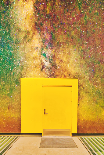 yellow door with night sky / milky way projection on the wall