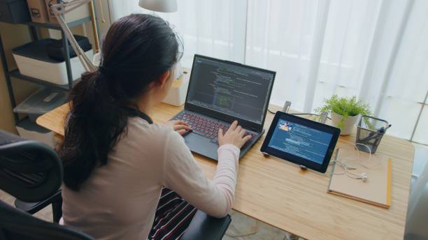 Programmer Teenager girl online learning coding with teacher at home Asian Teenager Girl learning online python coding class on laptop computer at home. Homeschool studying with programmer teacher on tablet while Lockdown. Education concept. python computer stock pictures, royalty-free photos & images