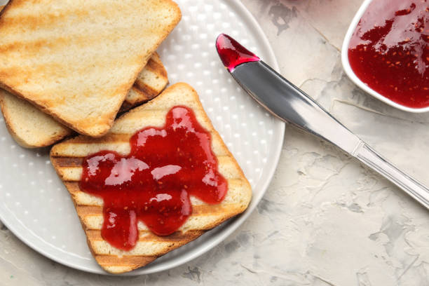 istock toasts with jam. fried crispy toasts with red jam on a light concrete table. breakfast. top view 1322665545