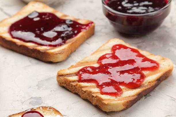 istock toasts with jam. fried crispy toasts with red jam on a light concrete table. breakfast. close-up 1322665577