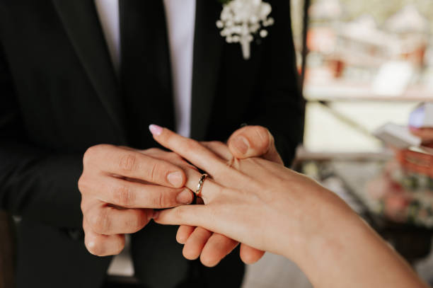 istock Groom putting wedding ring to bride hand during ceremony. 1322666858