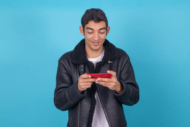 istock young man with mobile phone isolated on color background 1322667024