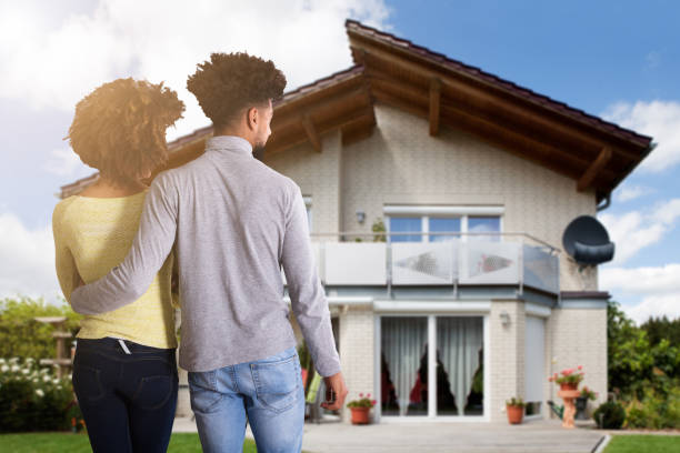 istock Couple Standing In Front Of House 1322669378