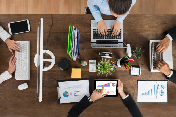 istock Businesspeople Working On Electronic Devices At Desk 1322670948